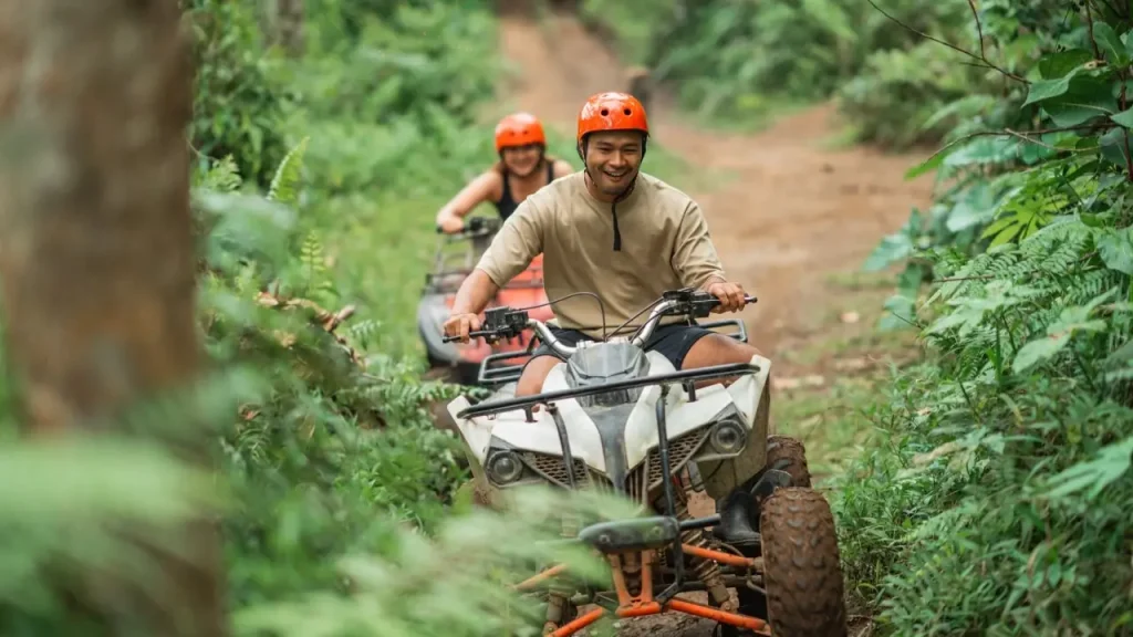Tourist riding ATV through rice fields and jungle trails in Ubud